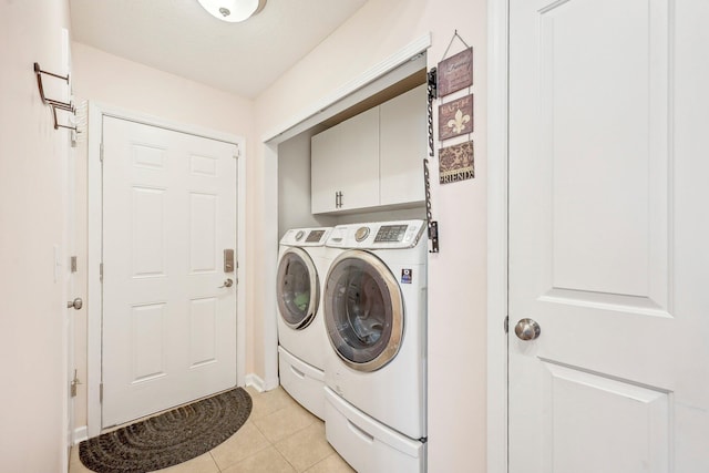 washroom with cabinets, light tile patterned flooring, and washer and dryer