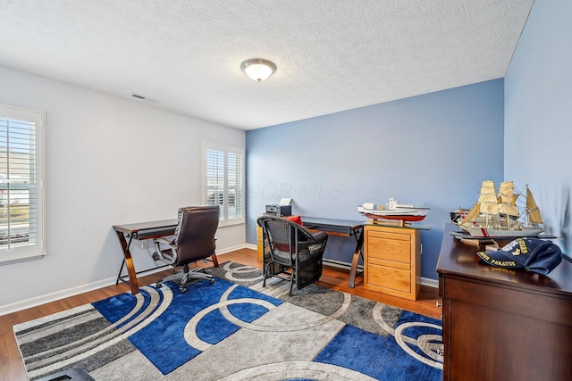 home office featuring hardwood / wood-style flooring and a textured ceiling