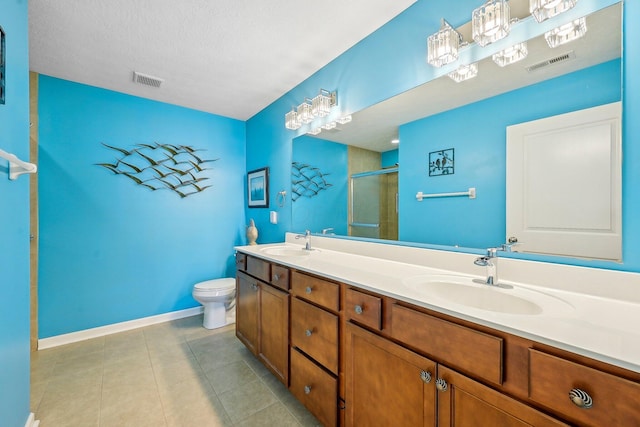 bathroom featuring vanity, tile patterned flooring, a shower with shower door, and toilet