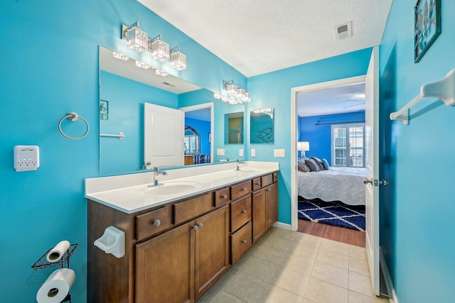 bathroom featuring tile patterned floors, vanity, and a textured ceiling