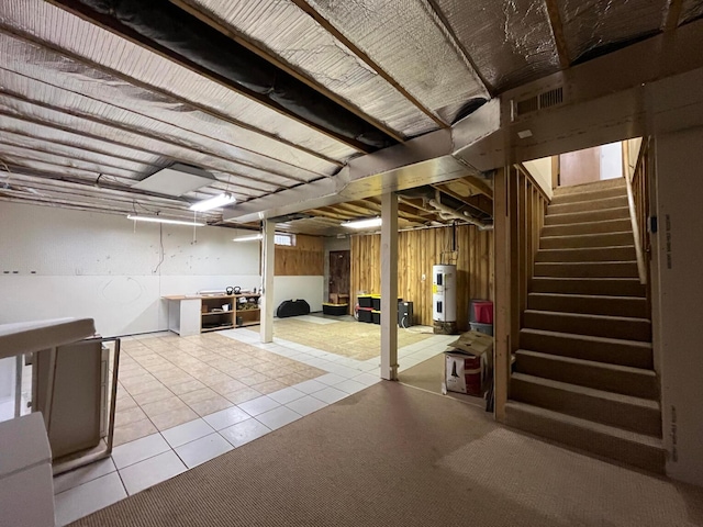 basement with water heater and light tile patterned floors