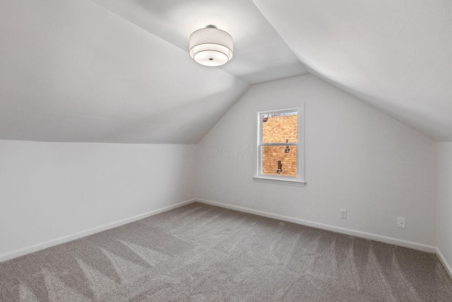 additional living space featuring vaulted ceiling and carpet