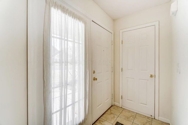 doorway to outside with light tile patterned flooring