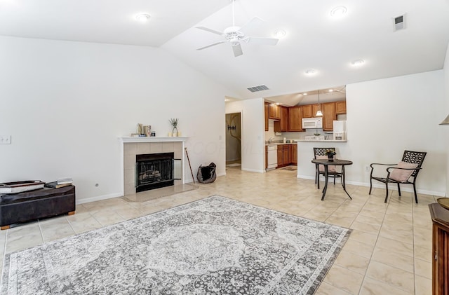 tiled living room featuring a fireplace, vaulted ceiling, and ceiling fan