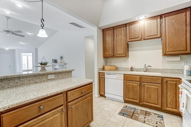 kitchen featuring pendant lighting, sink, white appliances, lofted ceiling, and light stone counters