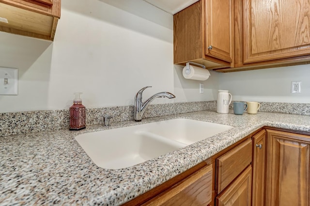 kitchen featuring sink and light stone counters