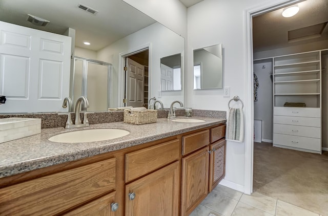 bathroom with tile patterned flooring, vanity, and an enclosed shower