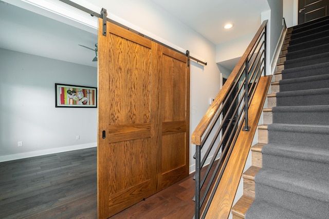 stairs with hardwood / wood-style flooring and a barn door