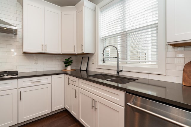 kitchen with tasteful backsplash, dishwasher, sink, and white cabinets