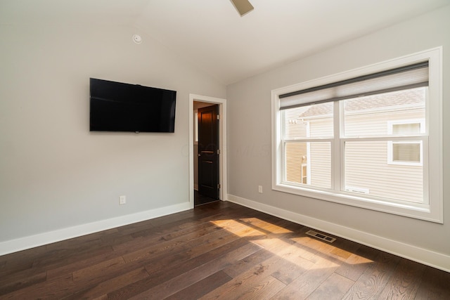 spare room with vaulted ceiling and dark hardwood / wood-style flooring