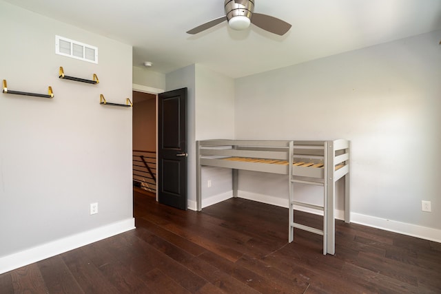 unfurnished bedroom featuring dark wood-type flooring and ceiling fan