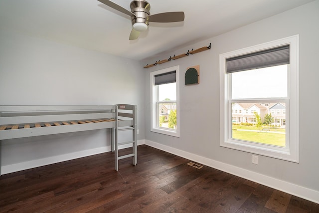 unfurnished bedroom with dark hardwood / wood-style floors and ceiling fan