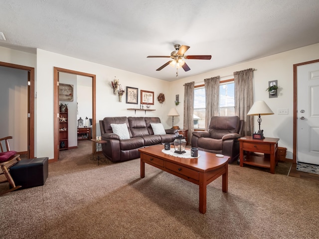 living room with ceiling fan, carpet flooring, and a textured ceiling