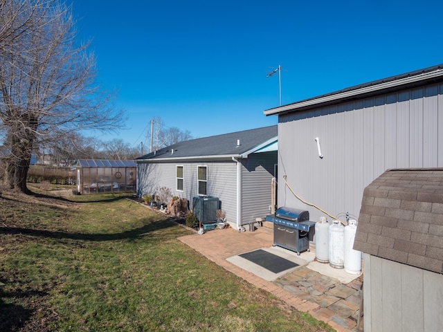 rear view of property featuring a patio, an outdoor structure, and a yard