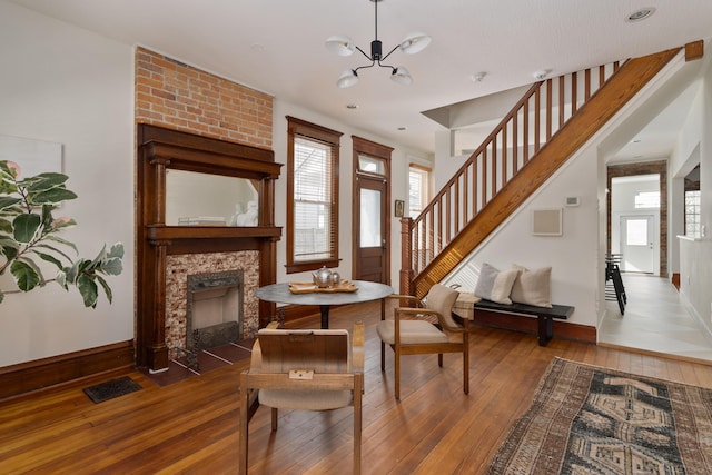 living room featuring a chandelier, dark hardwood / wood-style flooring, and a large fireplace