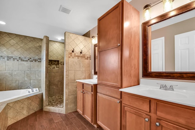 bathroom with vanity and shower with separate bathtub