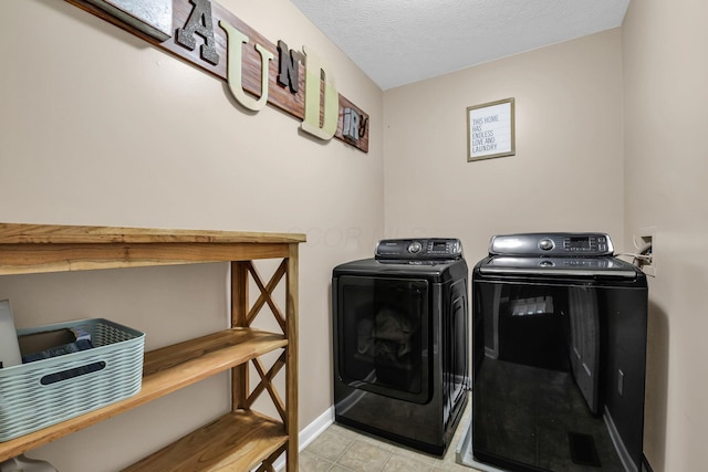 clothes washing area featuring washer and dryer and a textured ceiling