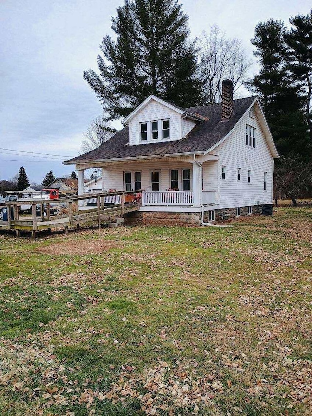 rear view of property with a yard and covered porch