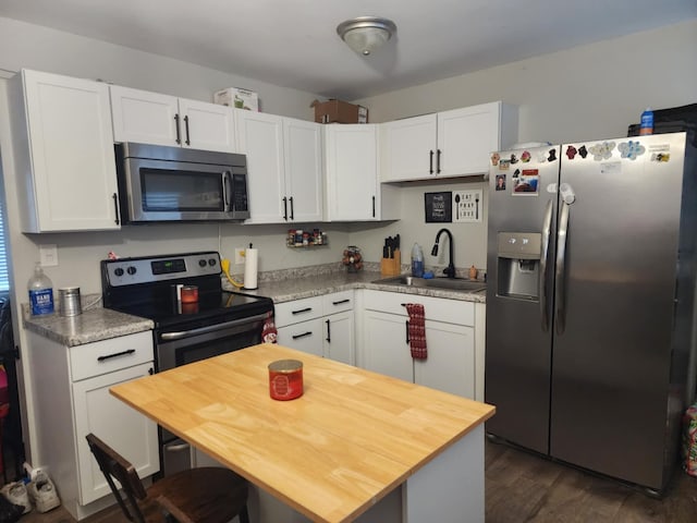 kitchen featuring appliances with stainless steel finishes, sink, and white cabinets