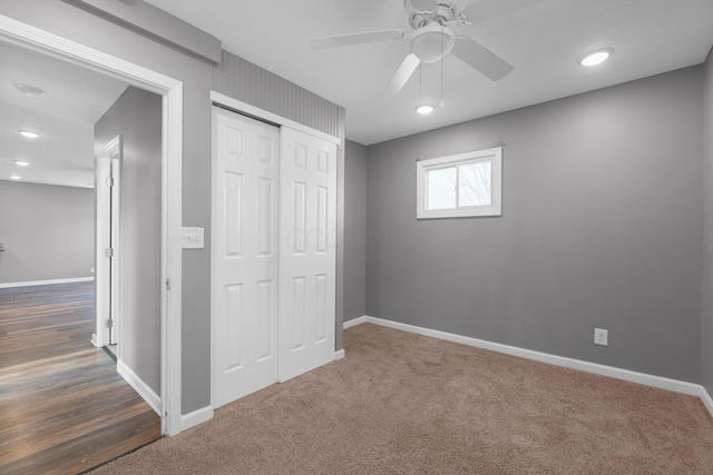 unfurnished bedroom featuring ceiling fan, dark carpet, and a closet