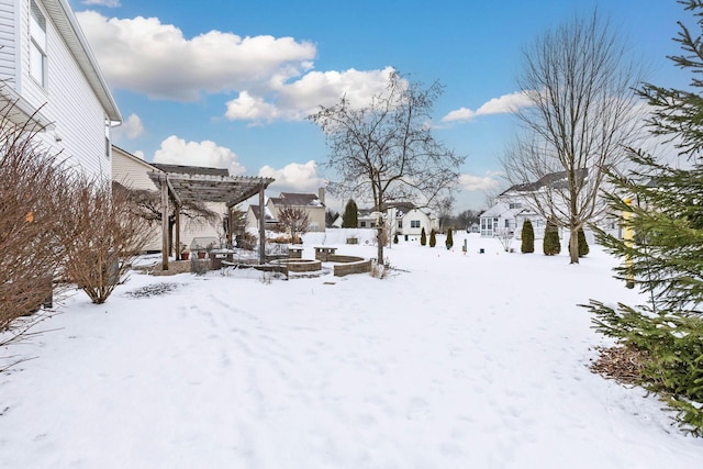 yard covered in snow with a residential view and a pergola