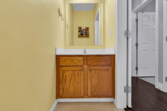 bathroom with vanity, baseboards, and wood finished floors