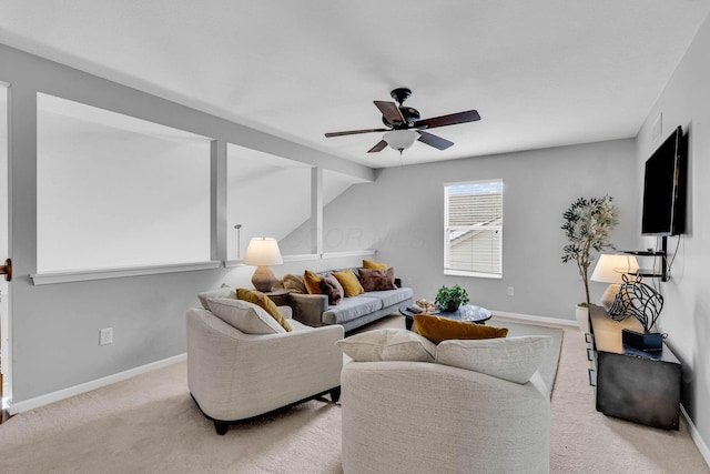 living area with light carpet, baseboards, and a ceiling fan