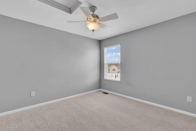 spare room with carpet, visible vents, baseboards, and a ceiling fan