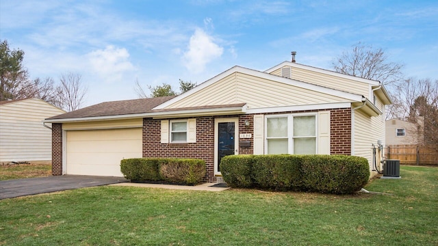 view of front of property featuring a garage, central AC, and a front lawn