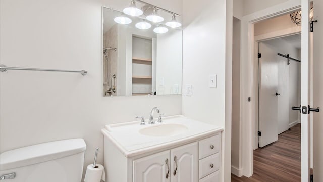 bathroom with hardwood / wood-style flooring, vanity, and toilet