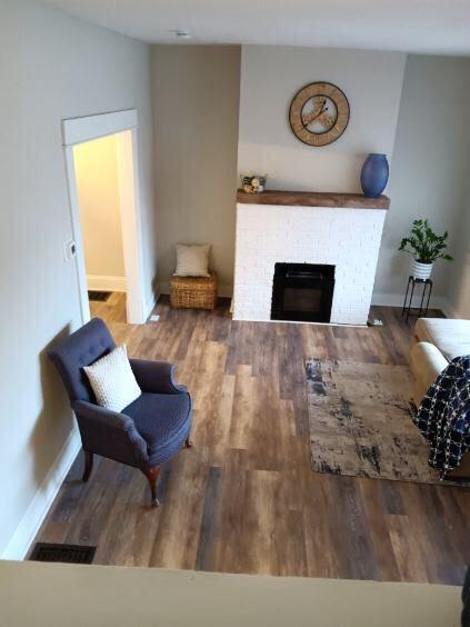 living room featuring a brick fireplace and hardwood / wood-style flooring