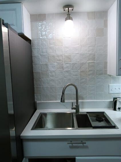 kitchen featuring tasteful backsplash, sink, and stainless steel fridge