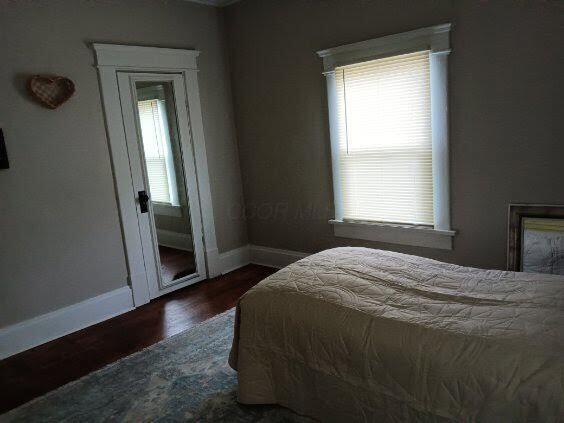 bedroom with dark wood-type flooring