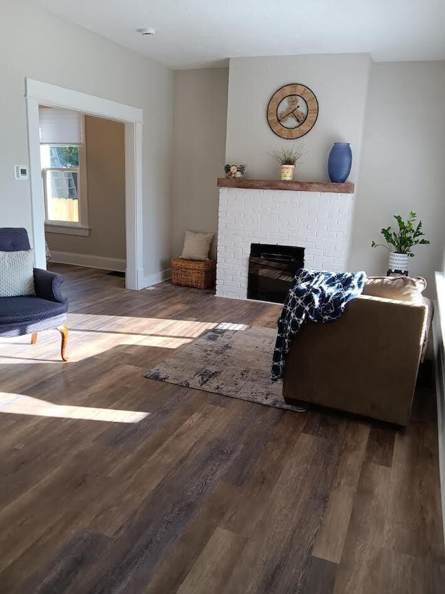 living room with dark wood-type flooring and a fireplace