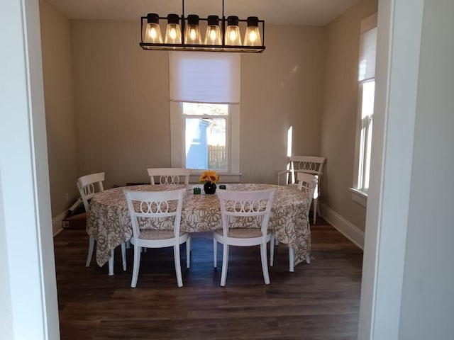 dining room featuring dark hardwood / wood-style flooring and an inviting chandelier