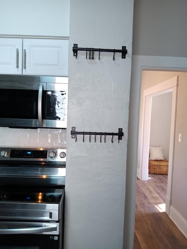 kitchen featuring white cabinetry, stainless steel appliances, and hardwood / wood-style floors