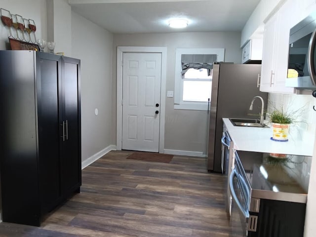 kitchen with white cabinetry, sink, dark hardwood / wood-style flooring, decorative backsplash, and stainless steel appliances