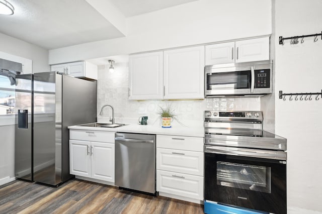 kitchen featuring stainless steel appliances, dark wood-type flooring, white cabinets, and backsplash