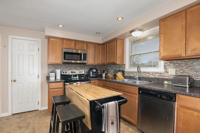 kitchen with stainless steel appliances, wooden counters, backsplash, a sink, and baseboards