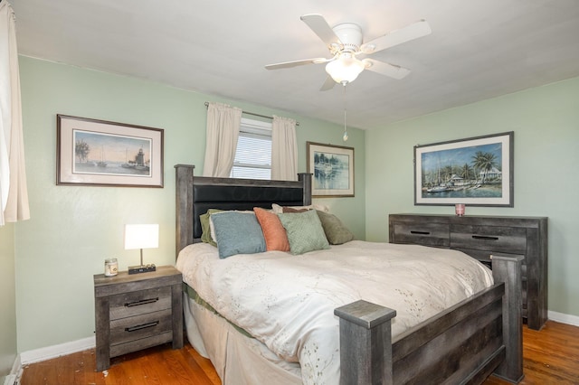 bedroom with wood finished floors, a ceiling fan, and baseboards