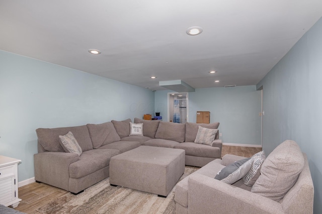 living area with light wood-type flooring, baseboards, and recessed lighting