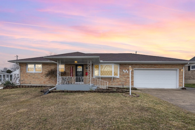 single story home with a garage, a front lawn, a porch, and concrete driveway