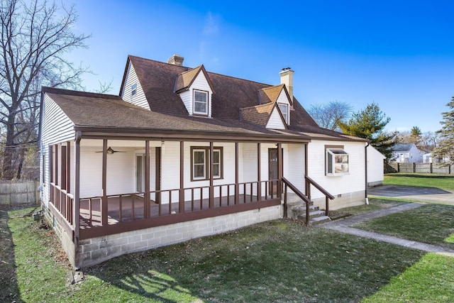 view of front facade featuring roof with shingles, a chimney, covered porch, crawl space, and a front lawn