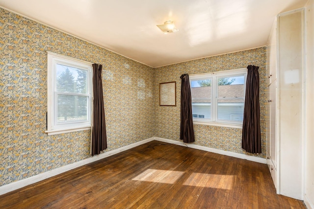 empty room with baseboards, dark wood-style flooring, and wallpapered walls