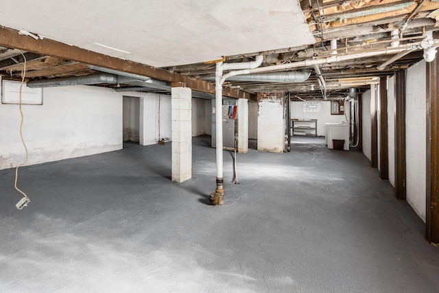 unfinished basement featuring heating unit and washer / clothes dryer