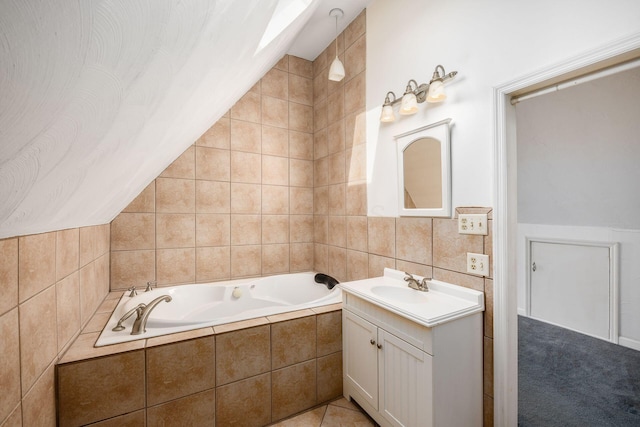 full bathroom with tile walls, vaulted ceiling, a bath, and vanity