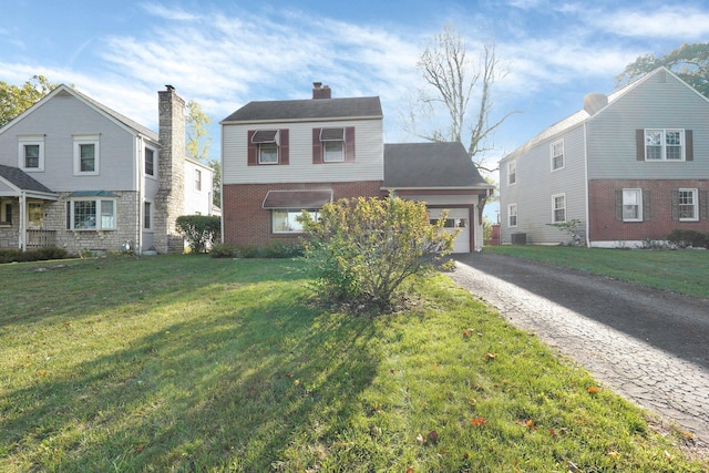 view of front of house featuring a chimney, a front lawn, a garage, aphalt driveway, and brick siding