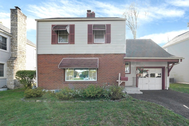 traditional-style house featuring a front yard, driveway, a chimney, a garage, and brick siding