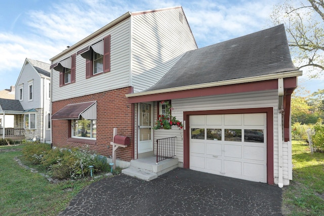 view of front of house featuring a garage, brick siding, and driveway