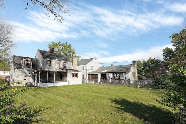 back of house with fence, central AC unit, a lawn, a chimney, and a sunroom